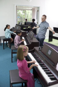 Greg and Students at the Piano Express